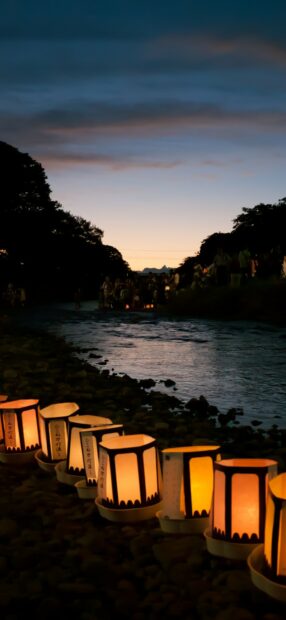 Traditional lanterns floating on a river at dusk during a cultural festival