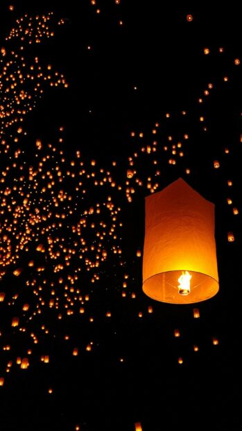 Bright lanterns floating into the night sky during a lanterns event
