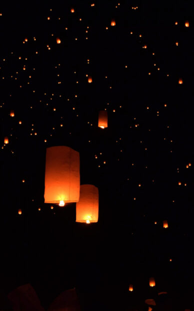 Glowing lanterns floating in the night sky during a lanterns celebration