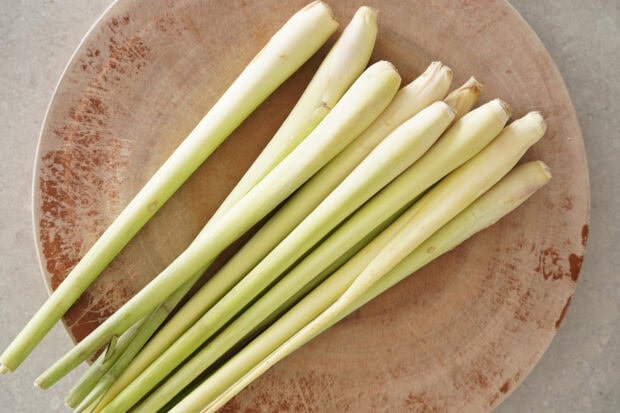 Fresh lemongrass stalks neatly arranged on a rustic wooden surface