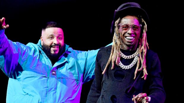Lil Wayne smiling with rapper in blue jacket on stage