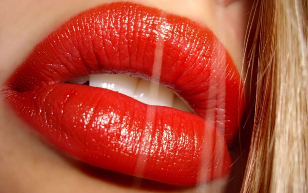 Close up of red lips with shiny lipstick and visible lip texture