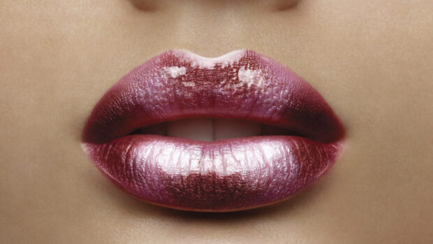 Close up of glossy lipstick lips with a shiny metallic finish