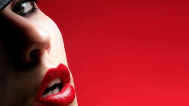 Close up of lips with red lipstick on a red background