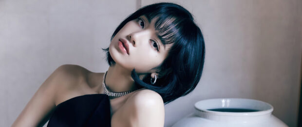 Lisa in a black outfit wearing a sparkling necklace and hoop earrings