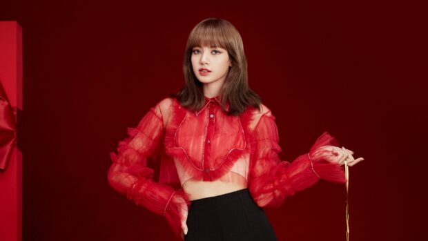 Lisa wearing a red sheer top posing confidently against a red background with Lisa Blackpink