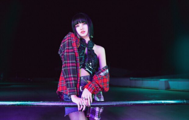 Lisa Blackpink wearing a red plaid shirt and jean skirt at night near a railing