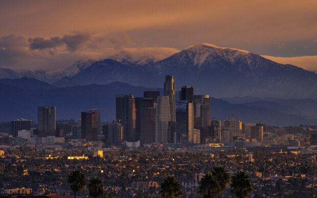 Los Angeles skyline with snowy mountains in the background at sunset