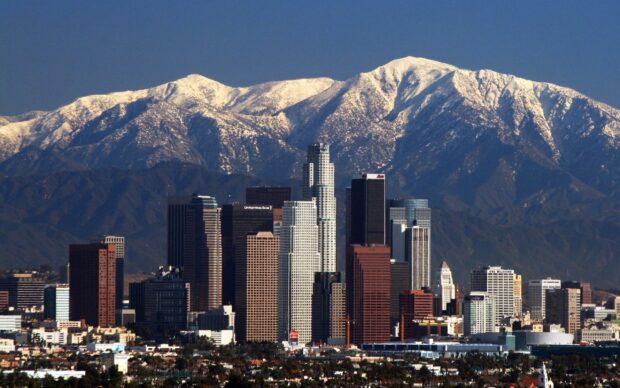 Snow capped mountains behind Los Angeles skyline in clear daylight