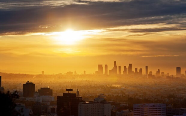 Los Angeles skyline view with a golden sunset illuminating the cityscape and buildings