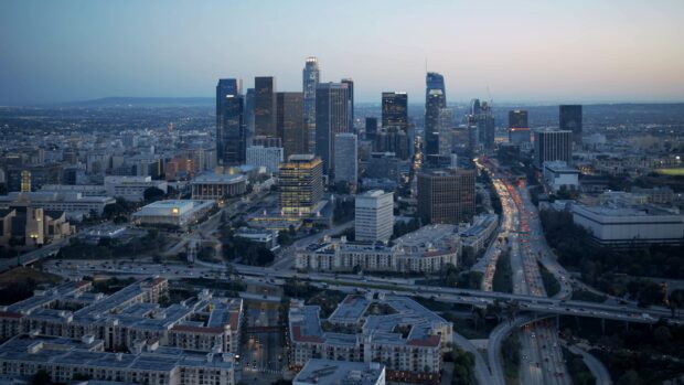 A high resolution Los Angeles city skyline view at dusk with illuminated buildings and busy highways