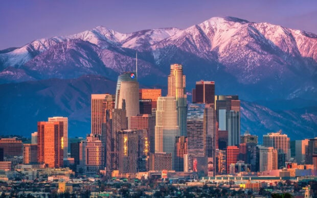 Los Angeles skyline with mountain range in the background during sunset
