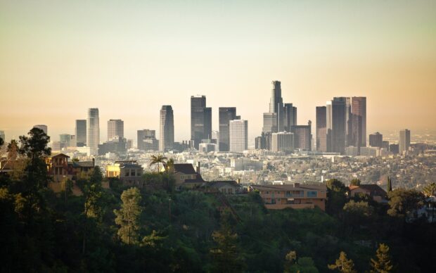 A clear view of Los Angeles skyline with buildings and hills in the foreground