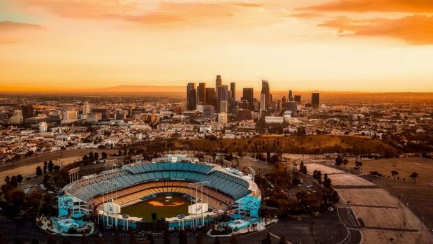 Los Angeles skyline with baseball stadium under a colorful sunset sky
