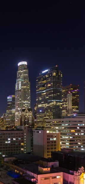 Night view of Los Angeles skyline buildings lit up with clear dark sky above