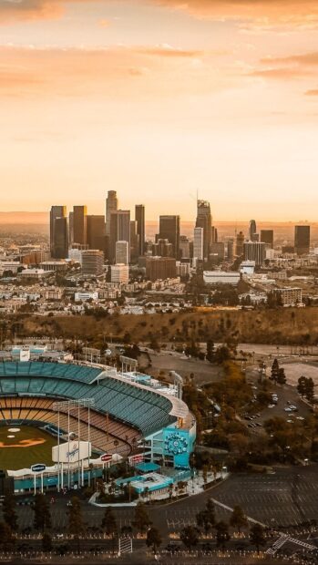 Downtown Los Angeles skyline view with a baseball stadium in the foreground at sunset