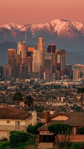 Los Angeles city skyline with snowy mountains in the background during sunset