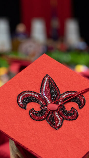 Red graduation cap with beaded Louisiana symbol design