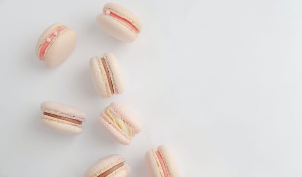 A close up of assorted macaron with various fillings on a white surface