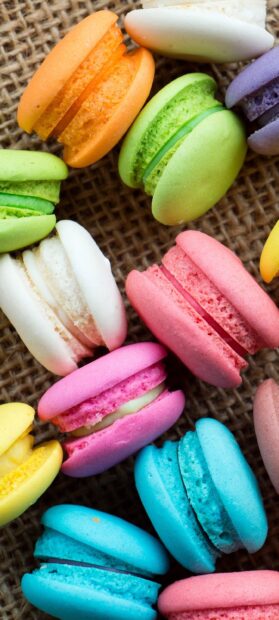 Colorful macaron assortment with green pink and blue flavors on rustic surface