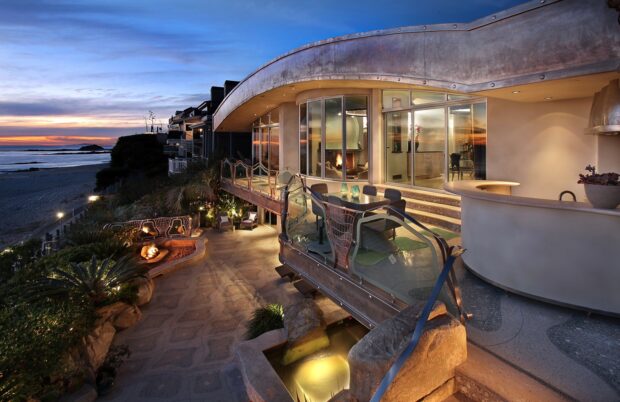 Modern mansion terrace with oceanview and firepit at sunset