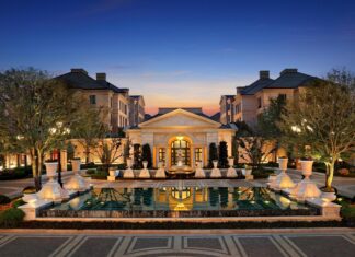 Luxurious mansion with elegant architecture and a large reflecting pool at dusk