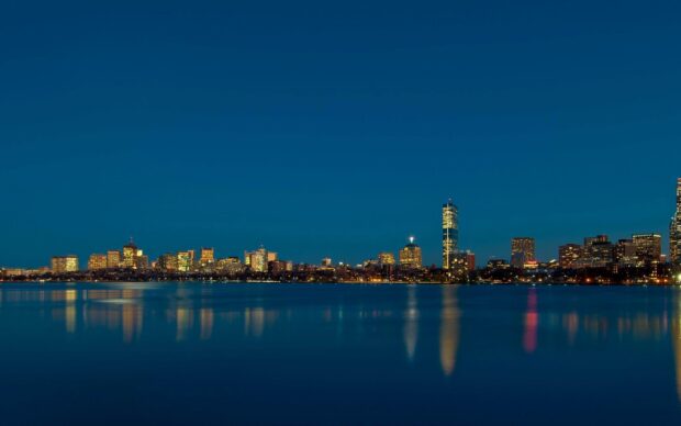 Night cityscape of Massachusetts reflecting on calm water surface