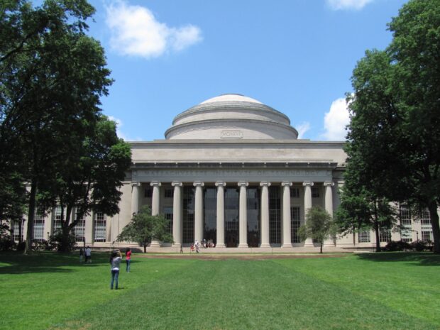 The Massachusetts Institute of Technology building surrounded by trees and green grass on a sunny day