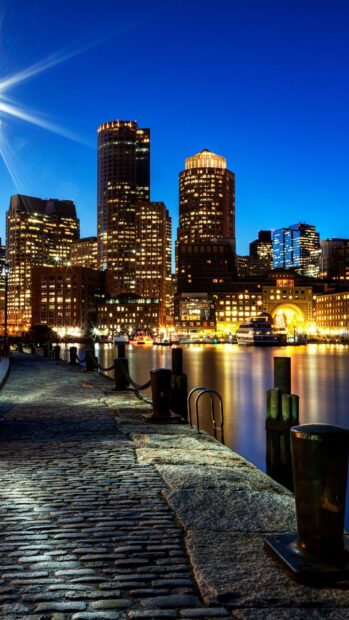 Nighttime cityscape of Boston with waterfront and illuminated skyscrapers in Massachusetts