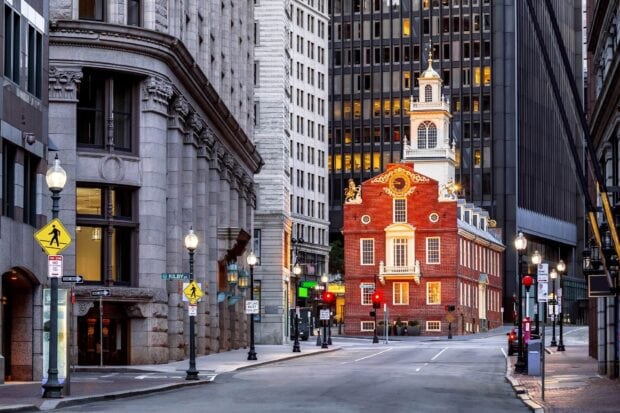 Historic building in Massachusetts with street signs and cityscape in the background