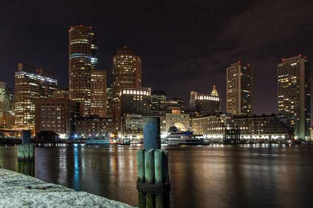 Night view of Massachusetts city skyline with illuminated buildings along the waterfront