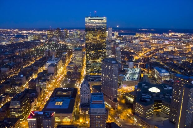 Nighttime cityscape of Massachusetts illuminated with building lights and bustling streets
