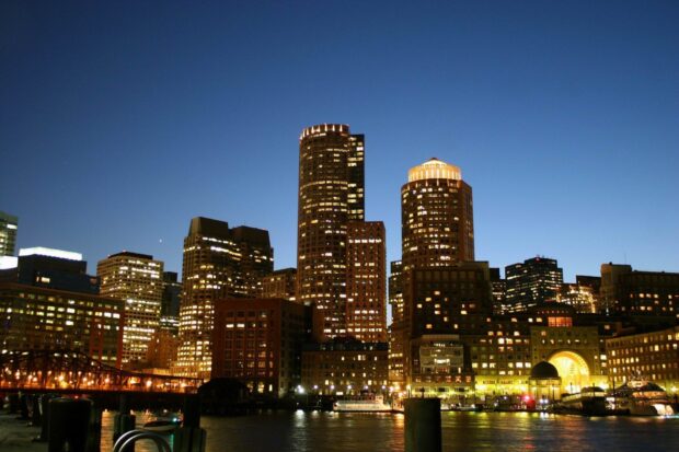 Nighttime cityscape of Massachusetts with illuminated skyscrapers and waterfront