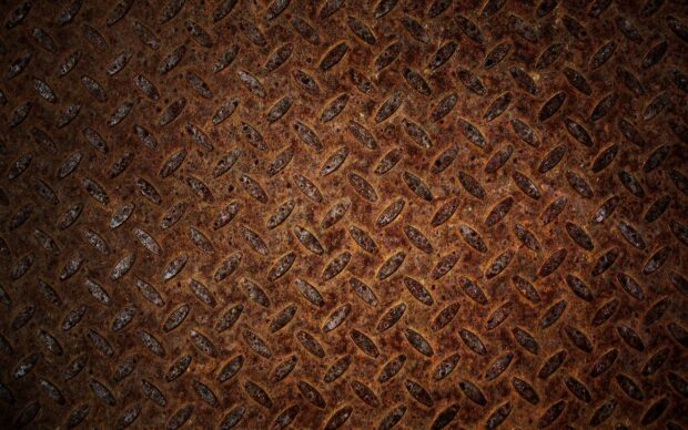 Rusted metal texture with diamond plate pattern covering the surface
