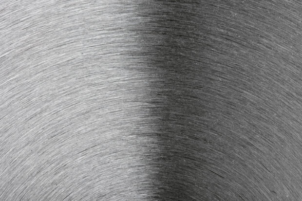 Circular brushed metal texture with detailed patterns on a steel surface