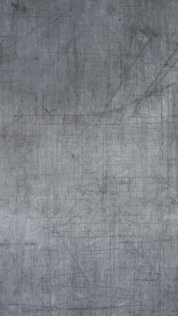 Detailed metal texture with numerous scratches and marks on a gray surface
