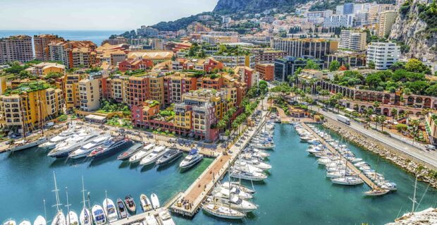 A vibrant Monaco cityscape with colorful buildings and luxury yachts docked at the marina
