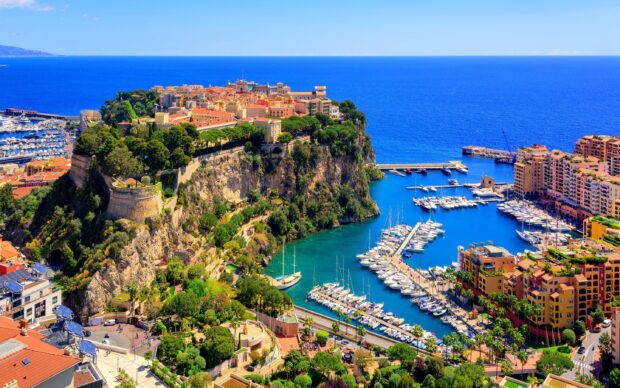 Scenic view of Monaco coastline with yachts and historic buildings on a sunny day