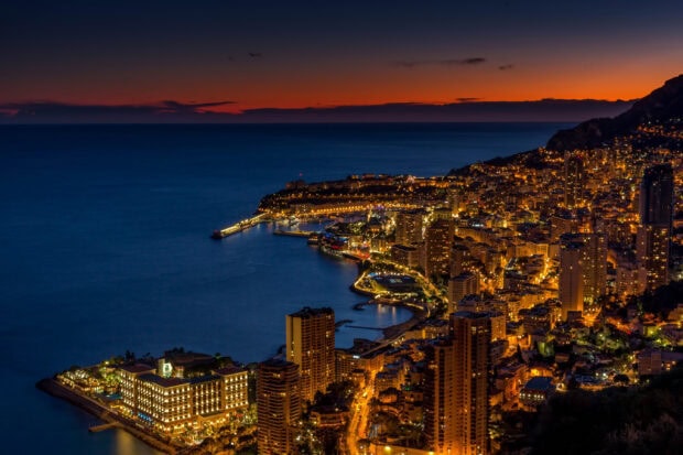 Stunning Monaco coastline at dusk with vibrant city lights and calm sea view