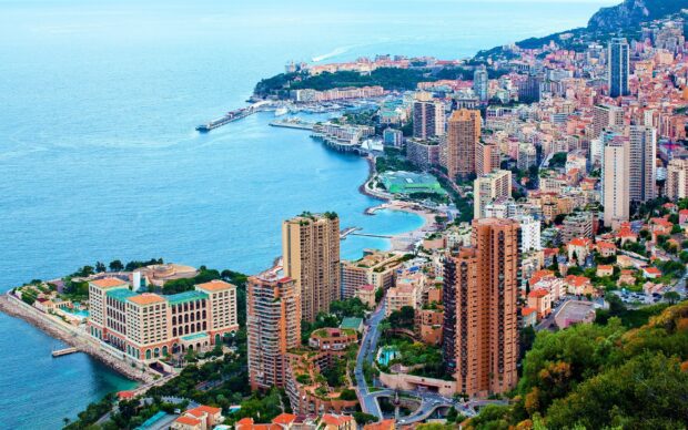 A panoramic view of Monaco cityscape with high rise buildings and the Mediterranean Sea coastline in clear weather