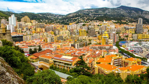 A vibrant view of Monaco cityscape with colorful buildings and lush greenery under a cloudy sky