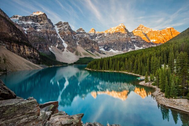 Mountain range with Moraine lake and green forests reflections in the water