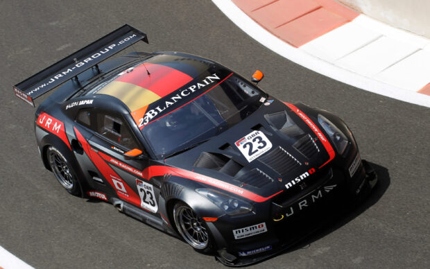 Black and red Nissan GT racing car with number 23 competing on race track