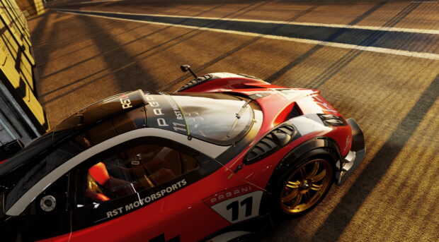 Red Pagani race car on the track with RST motorsports branding in golden hour sunlight