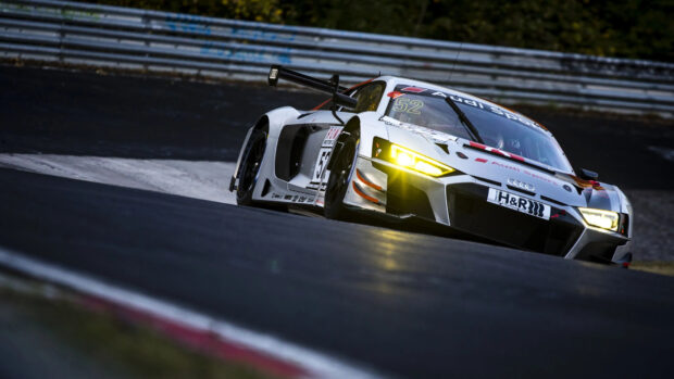 White Audi race car speeding on the racetrack during motorsports event