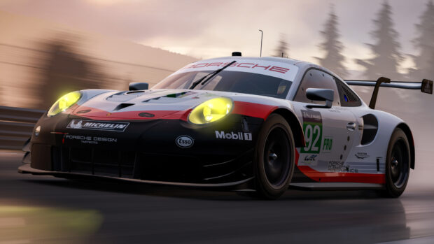 A Porsche racecar speeding on a racetrack during a motorsports competition at sunset