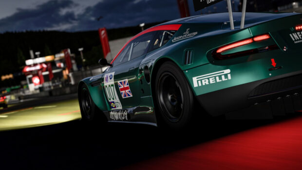 Green race car with number 007 and British flag on track at night