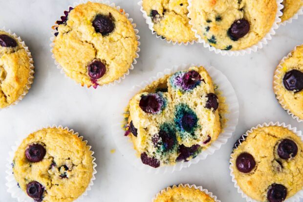 Fresh blueberry muffin with a broken piece showing juicy berries inside