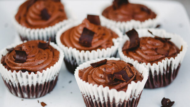 Chocolate muffins with rich frosting and chocolate shavings close up view