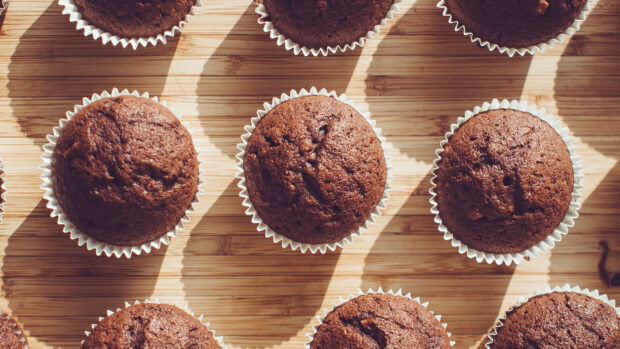 Close up of chocolate muffin on wooden surface in natural light